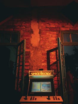 A classic arcade machine brightly illuminates a rustic brick wall, creating a nostalgic gaming ambiance.
