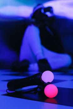 Close-up of a VR motion controller with a person wearing a headset in the background, showcasing gaming technology.